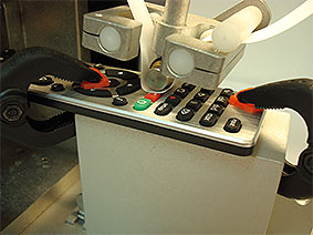 Detail of RCA Abrasion Wear Tester testing a remote control keypad